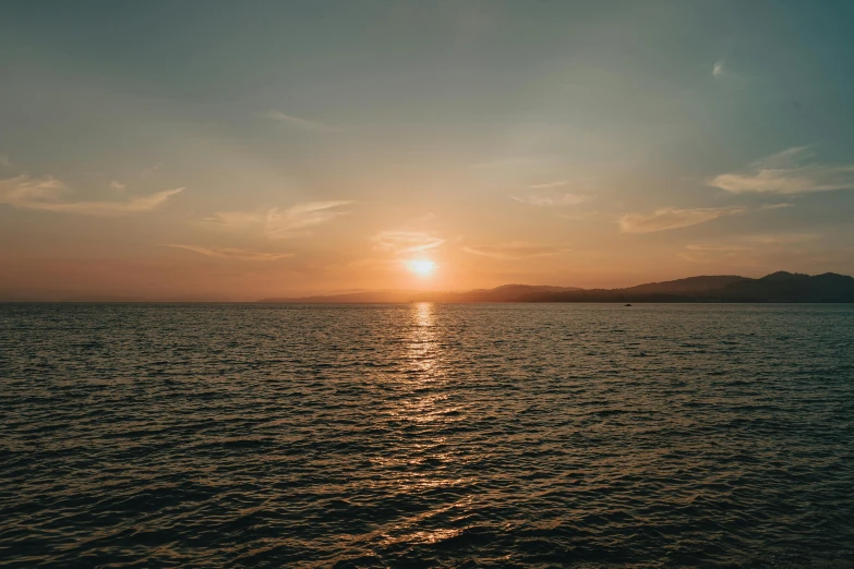 the sun is setting over a body of water, pexels contest winner, slightly tanned, calm environment, split near the left, youtube thumbnail