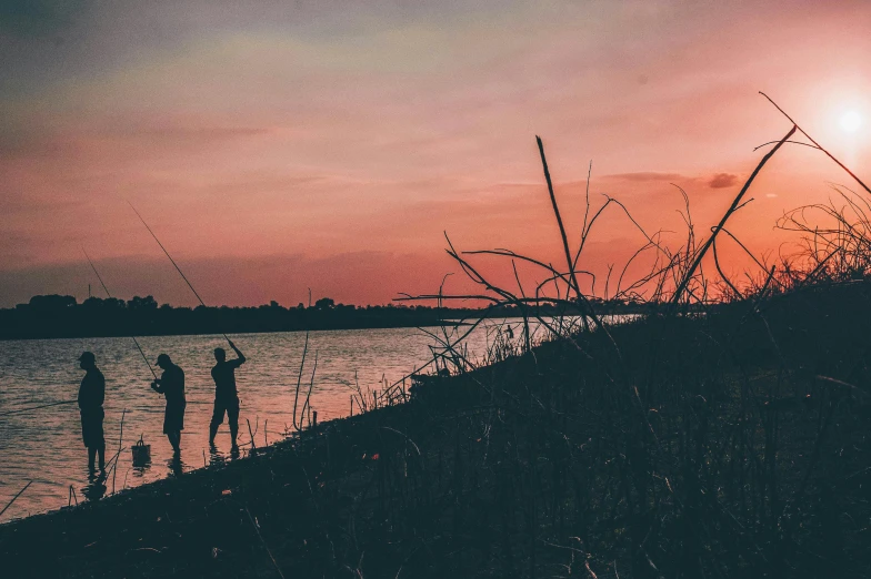 a group of people standing next to a body of water, pexels contest winner, romanticism, fishing pole, pink sunset, on a riverbank, header