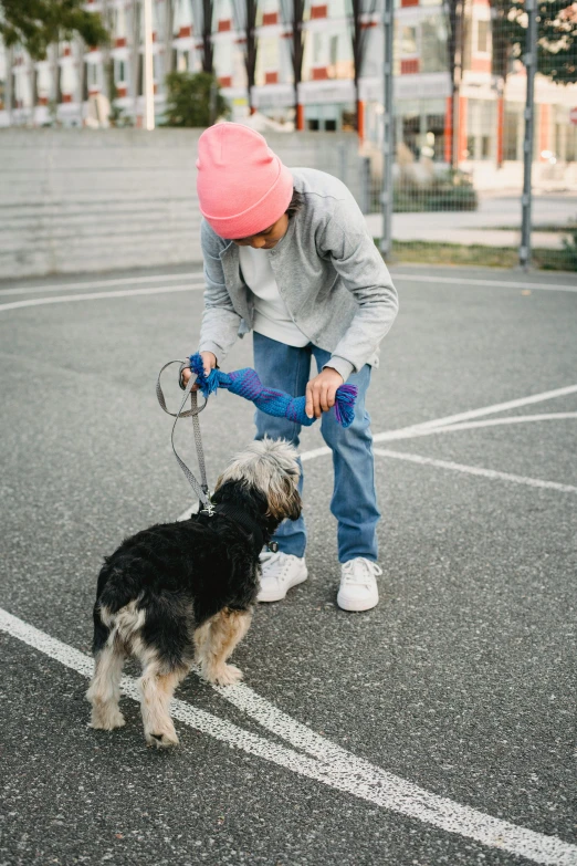 a person with a dog on a leash in a parking lot, by Jan Tengnagel, dribble, happening, playing, wearing a neon blue hoodie, ashy, asher duran