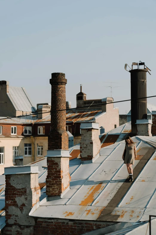 a person walking on the roof of a building, by Adam Marczyński, chimneys on buildings, galvalume metal roofing, quaint, background image