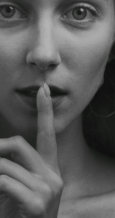 a black and white photo of a woman with a finger on her lips, by Maria van Oosterwijk, unsplash, surrealism, hidden message, closeup photo, contracept, sirens