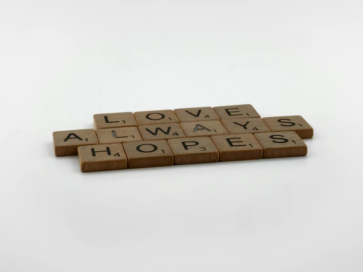 a couple of scrabbles sitting on top of each other, inspired by Ian Hamilton Finlay, light brown, close-up product photo, hope, on a white background
