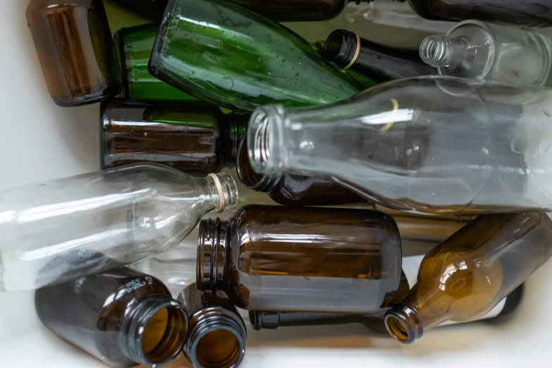 a pile of empty bottles sitting on top of a table, pexels, glass openings, thumbnail, 1 6 x 1 6, brown