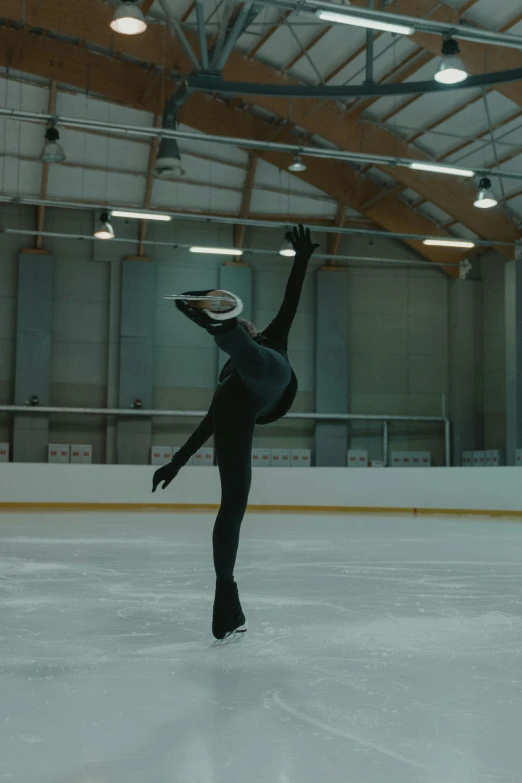 a man in a black suit skating on an ice rink, by Jacob Toorenvliet, arabesque, **cinematic, wearing skating helmet, performing a music video, spreading her wings