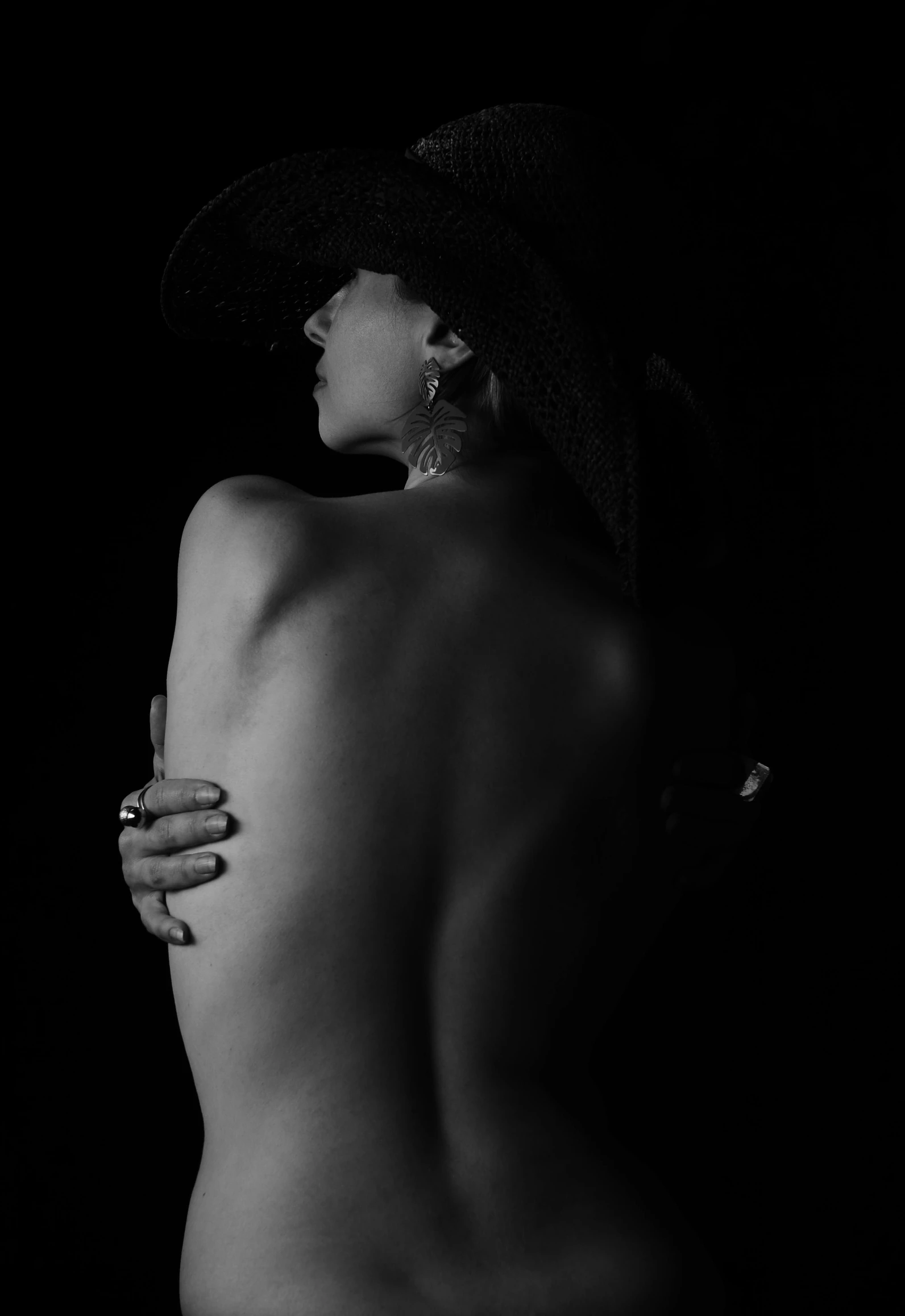 a black and white photo of a woman in a hat, inspired by Robert Mapplethorpe, figurative art, bare back, deviantart artstation cgscosiety, dark vibes, studio medium format photograph