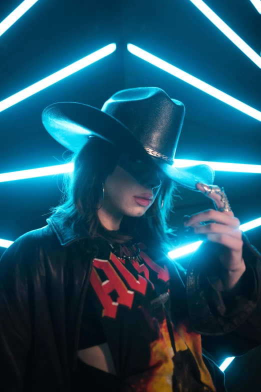a man in a cowboy hat holding a cell phone, an album cover, inspired by Elsa Bleda, trending on pexels, pop art, cosplay on black harley queen, charli bowater, official music video, leather clothing