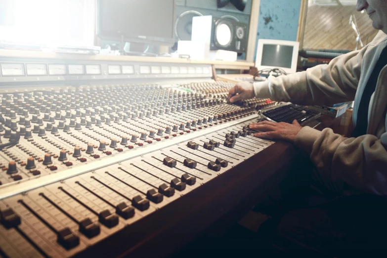 a man sitting in front of a mixing desk, by David Donaldson, pexels, private press, multiple stories, brown, instagram picture, where a large