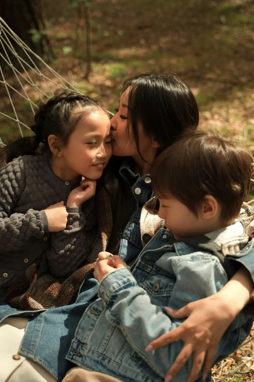 a woman and two children sitting in a hammock, inspired by Li Di, pexels contest winner, kissing together, gong li, medium shot close up, promotional image