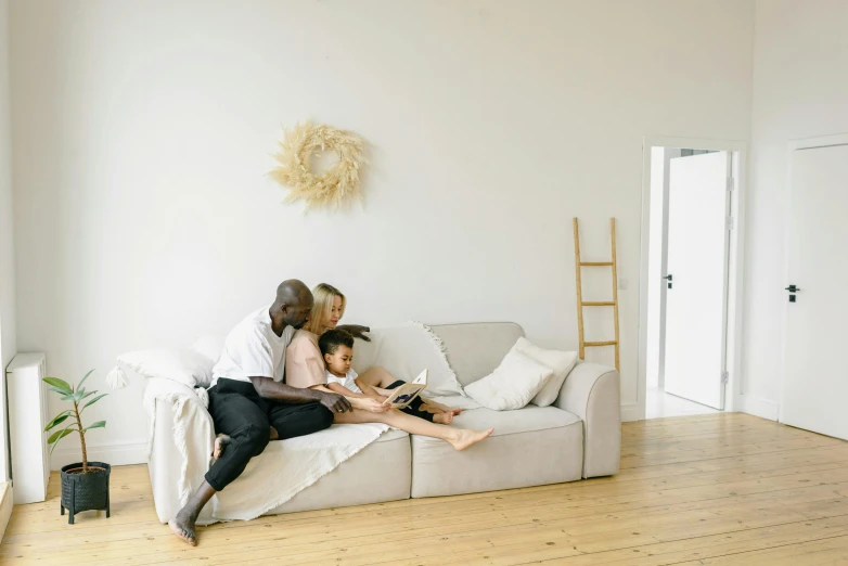 a woman and a child are sitting on a couch, pexels contest winner, minimalism, families playing, white l shaped couch, 3 - piece, people looking at a house
