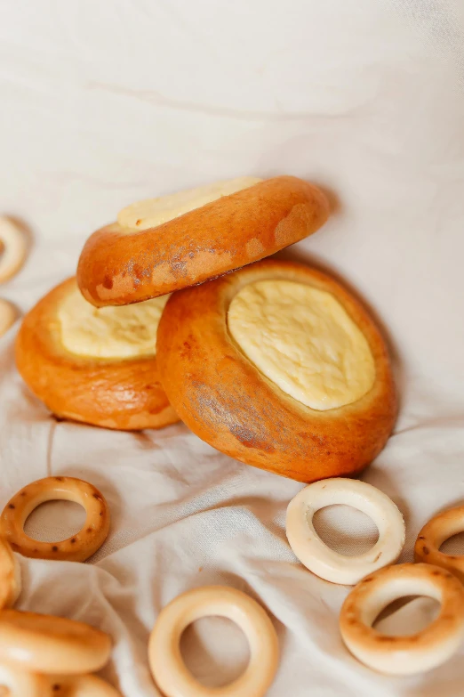 a pile of pretzels sitting on top of a table, inspired by Károly Markó the Elder, reddit, art nouveau, made of cheese, blender donut, professional product photo, natural soft rim light