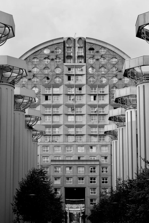 a black and white photo of a tall building, inspired by Ricardo Bofill, berlin secession, honeycomb halls, front view 1 9 9 0, electricity archs, penthouse