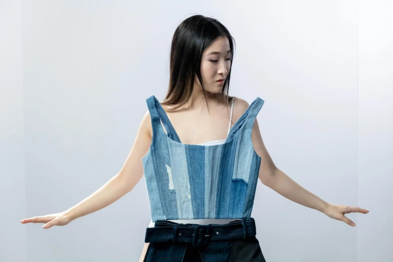 a woman that is standing up with her hands out, an album cover, inspired by Kim Tschang Yeul, unsplash, gutai group, wearing denim, model is wearing techtical vest, open top, croptop