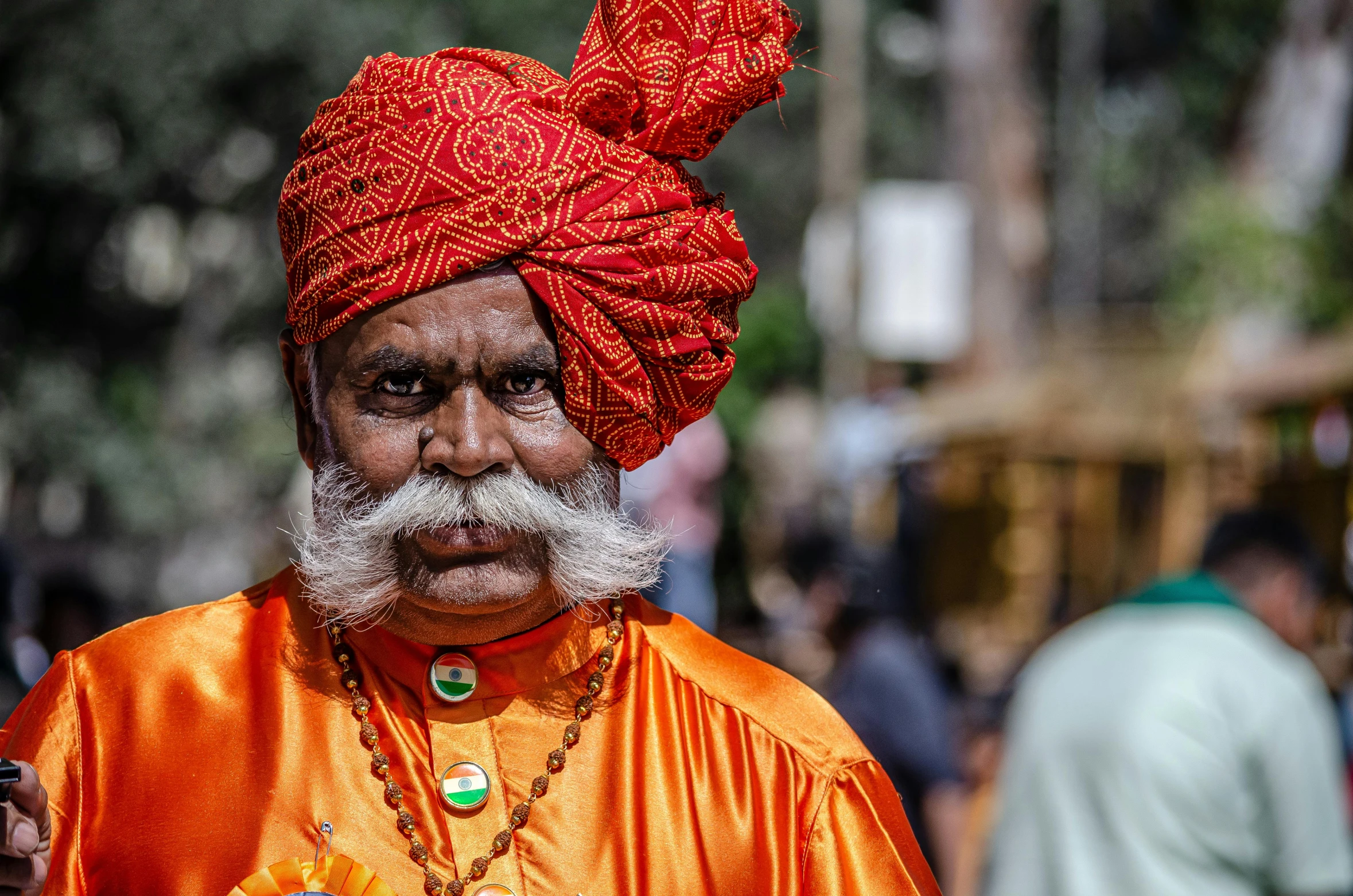 a man wearing an orange outfit and a red turban, pexels contest winner, samikshavad, avatar image, gorgeous and huge head ornaments, old male, wearing a fancy dress