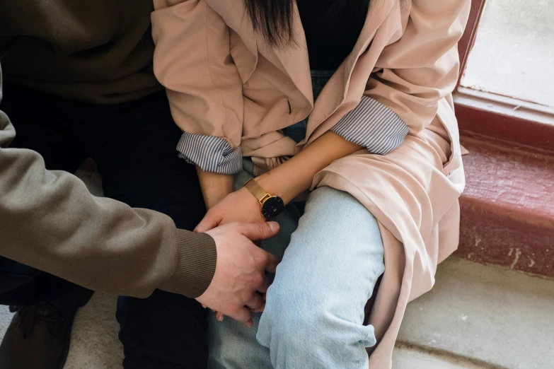 a man and a woman sitting next to each other, trending on pexels, romanticism, handcuffed, wearing jacket, asian female, woman holding another woman