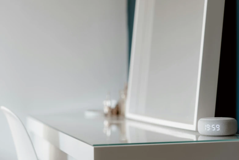 a clock sitting on top of a table next to a mirror, close up details, gloss finish, white frame, micro-details