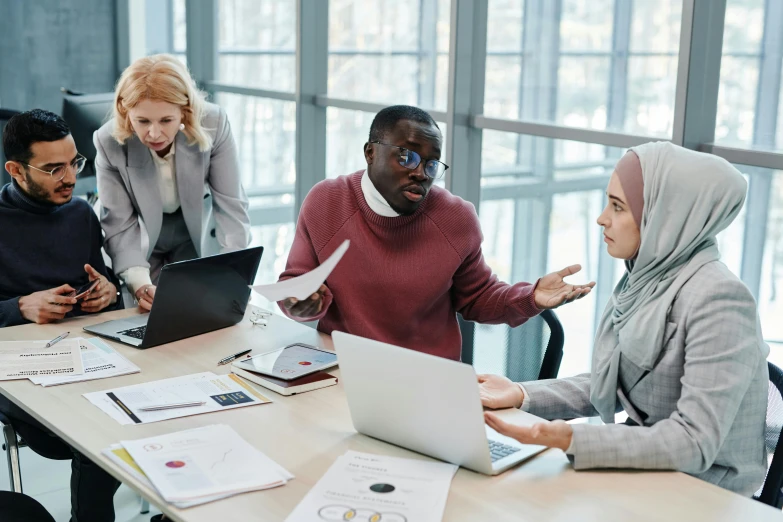 a group of people sitting around a table with laptops, trending on pexels, hurufiyya, avatar image, professional image, ethnic group, modest