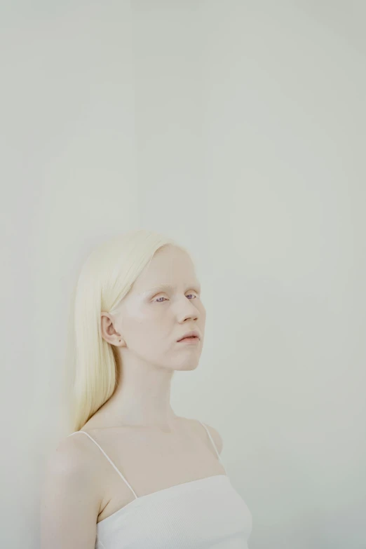 a woman with blonde hair standing in front of a white wall, an album cover, inspired by Vanessa Beecroft, portrait of albino mystic, head and shoulders view, a woman's profile, prosthetic