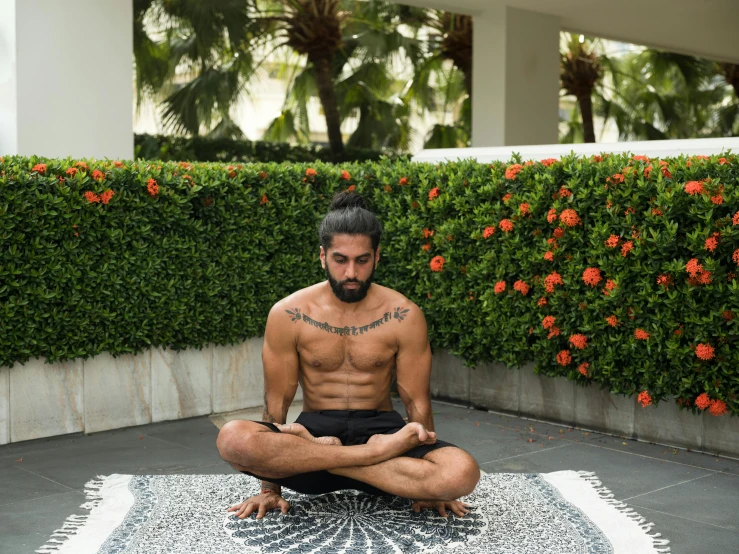 a man sitting in the middle of a yoga pose, kyza saleem, lush surroundings, profile image, symmetrical centered