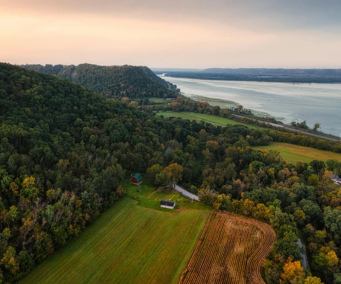 an aerial view of a farm with a lake in the background, pexels contest winner, hudson river school, golden hour photo, trees and cliffs, slide show, old american midwest