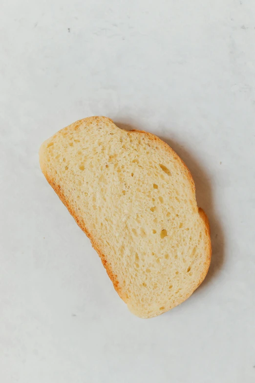 a piece of bread sitting on top of a counter, soft oval face, petite, vanilla, overview