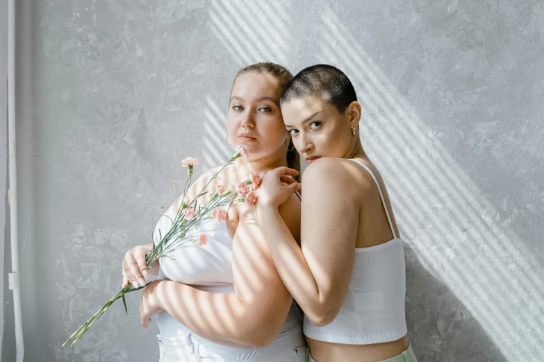 a couple of women standing next to each other, a photo, inspired by Wang Duo, trending on pexels, renaissance, shaved head, in white room, blooming, female bodies