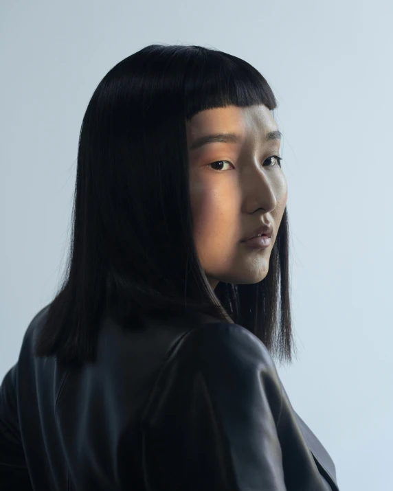 a woman standing in front of a white wall, an album cover, inspired by Kim Tschang Yeul, trending on unsplash, neo-figurative, cyberpunk dyed haircut, jingna zhang, in front of a black background, demna gvasalia