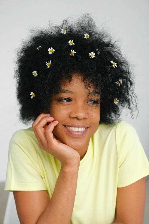 a woman with a flower in her hair, wavy hair yellow theme, with afro, chamomile, promo image