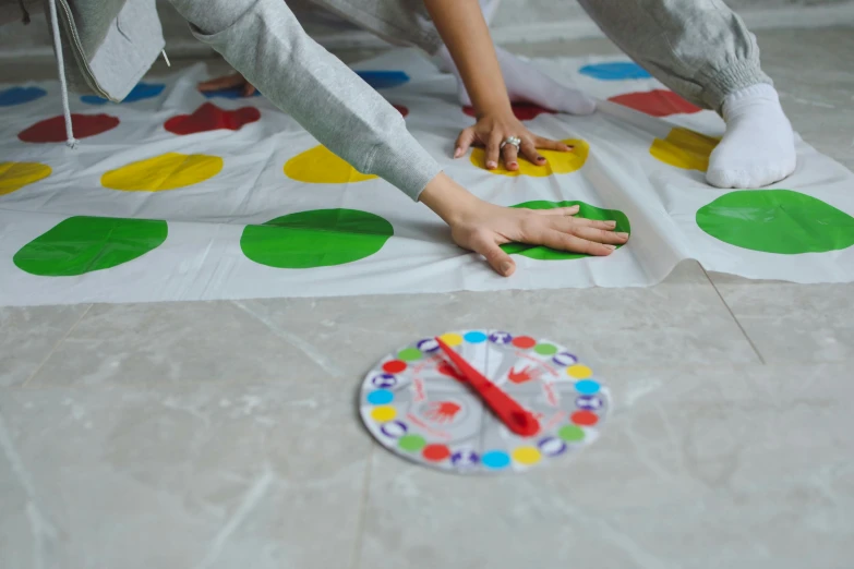 a person is playing a game on the floor, by Julia Pishtar, pexels contest winner, twister, white tablecloth, promo image, 15081959 21121991 01012000 4k