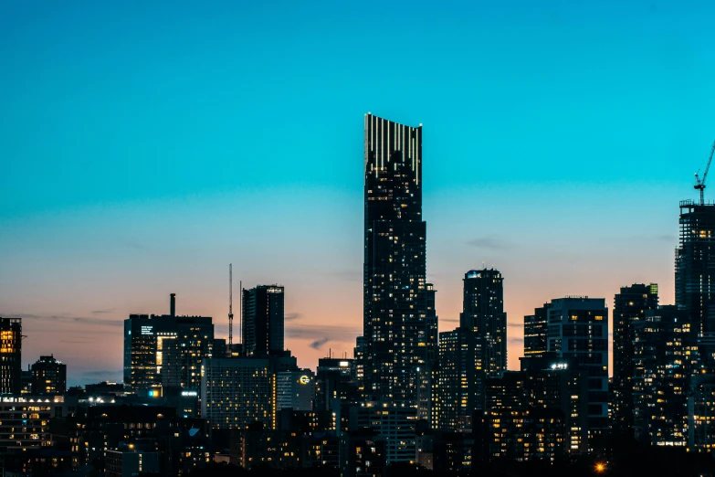 the city skyline is lit up at night, an album cover, unsplash contest winner, tall thin build, early evening, melbourne, new york buildings