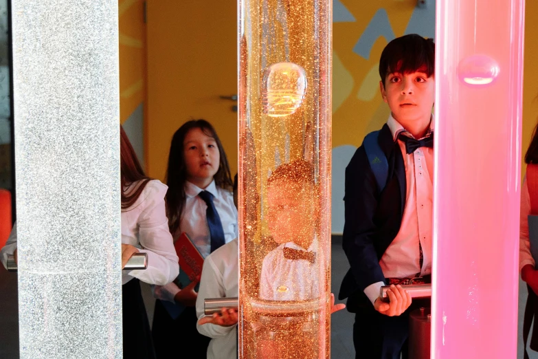 a group of people standing next to each other, interactive art, crystal column, magical school, liquid gold, very award - winning