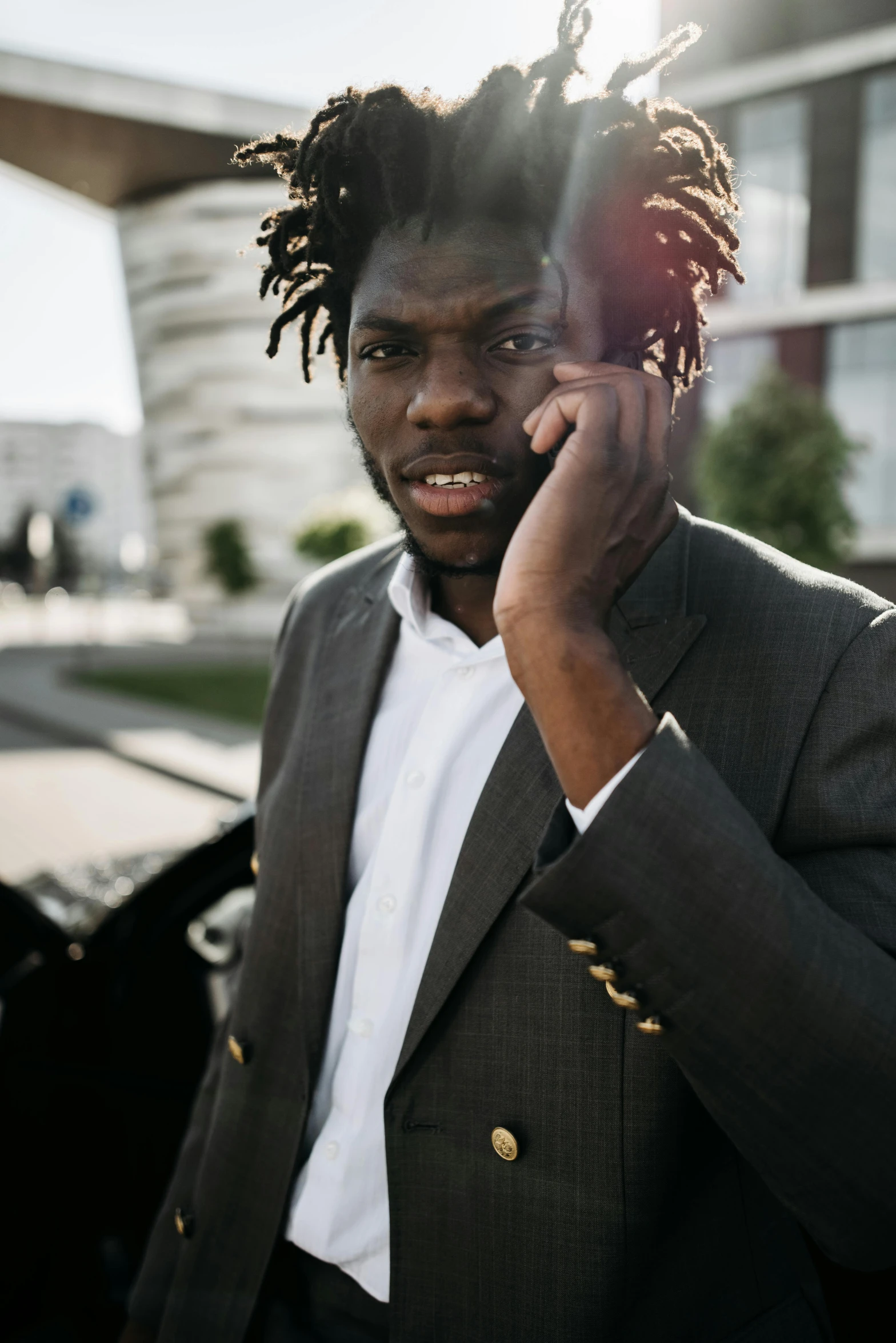 a man with dreadlocks talking on a cell phone, pexels contest winner, wearing causal black suits, ( ( dark skin ) ), lean man with light tan skin, afro tech