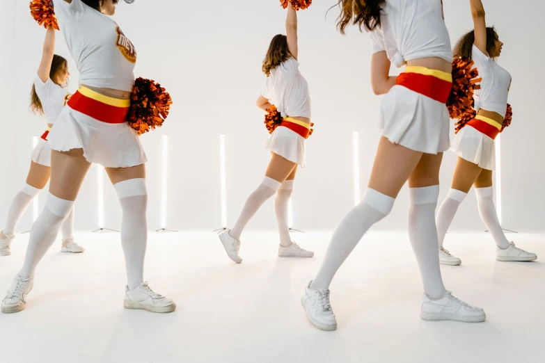 a group of cheerleaders holding pom poms, trending on pexels, process art, white skirt, inside white room, orange and red lighting, cosplay photo