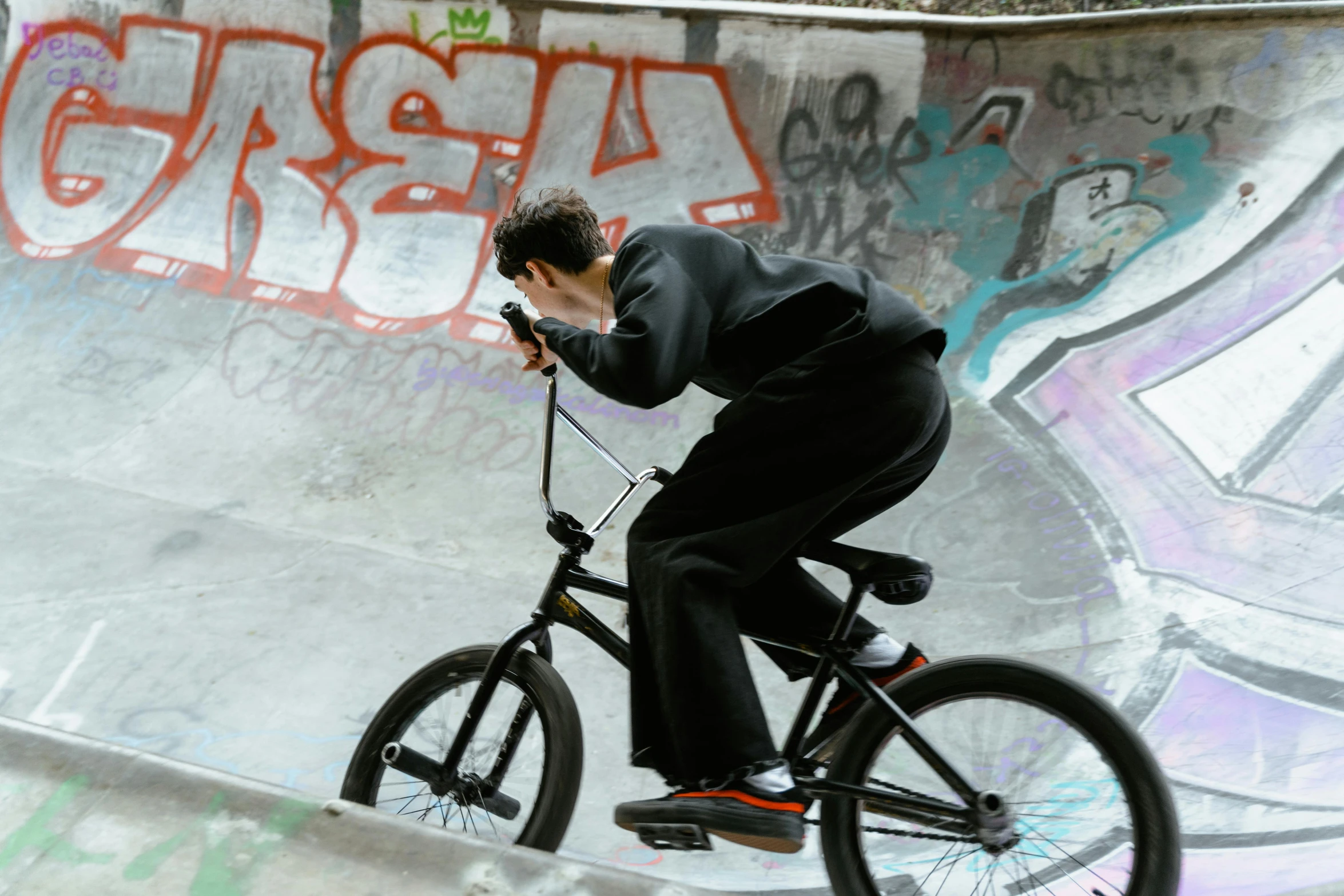 a man riding a bike up the side of a ramp, inspired by Seb McKinnon, pexels contest winner, a man wearing a black jacket, at a skate park, scribbled, snacks