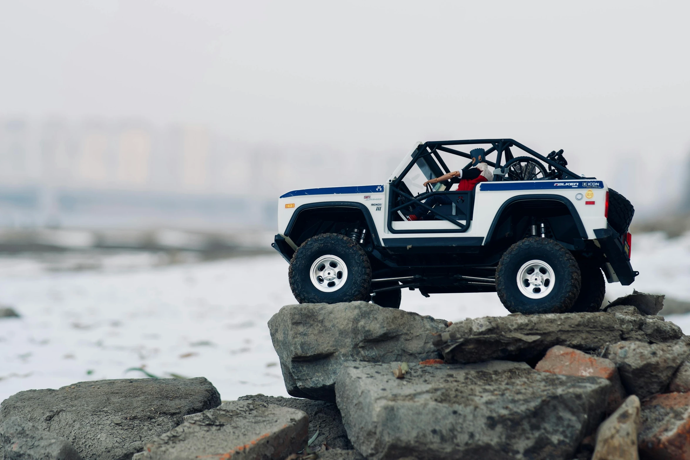 a toy jeep sitting on top of a pile of rocks, unsplash, “hyper realistic, winter season, fully body photo, [ cinematic