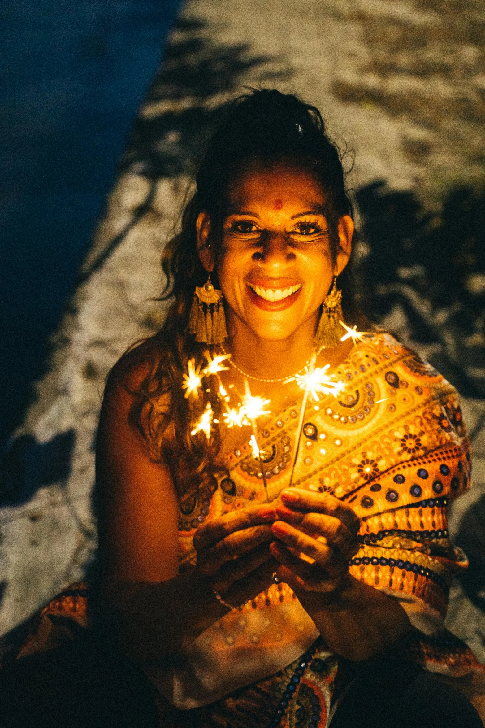 a woman holding sparklers in her hands, a portrait, pexels contest winner, happening, beautiful tan mexican woman, kundalini energy, delightful surroundings, intricate led jewellery