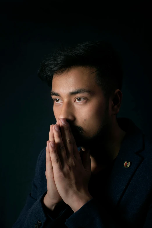 a man is praying in a dark room, an album cover, inspired by Li Tiefu, pexels contest winner, hurufiyya, lgbtq, south east asian with round face, solemn gesture, patriotism