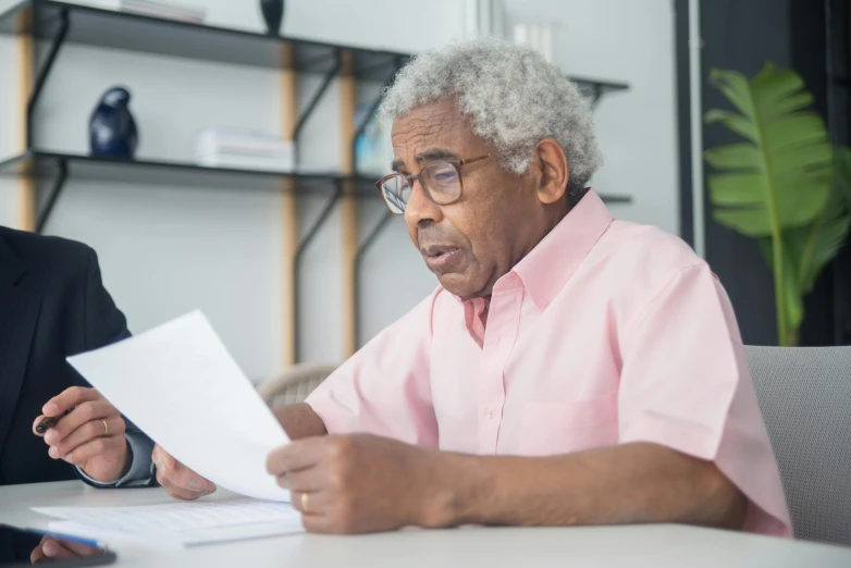 a man and a woman sitting at a table with papers, pexels contest winner, gray haired, trying to read, profile image, malcolm hart