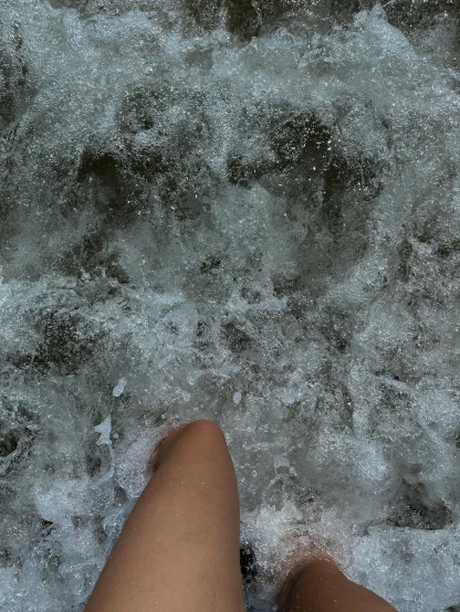 a person standing next to a body of water, happening, bubbling skin, legs taking your pov, no filter, white water