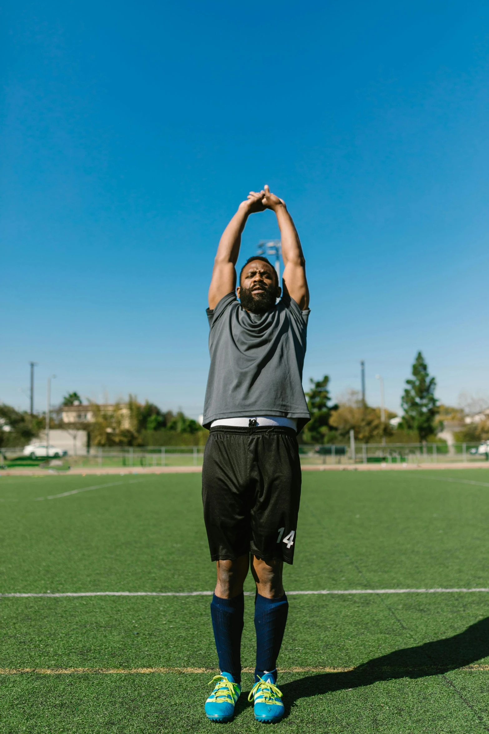 a man standing on top of a soccer field, stretch, bearded and built, jemal shabazz, square