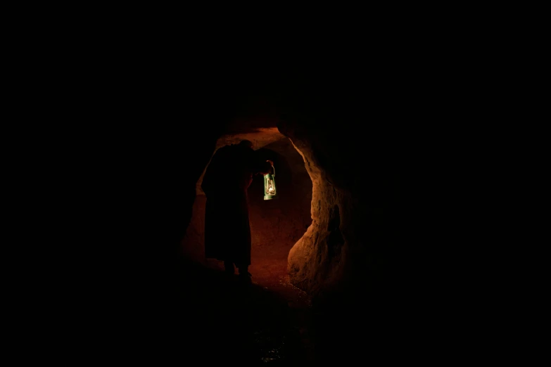 a man standing at the end of a tunnel in the dark, by Elsa Bleda, conceptual art, inside the tomb of jesus, slide show, portrait of bedouin d&d, medium-shot