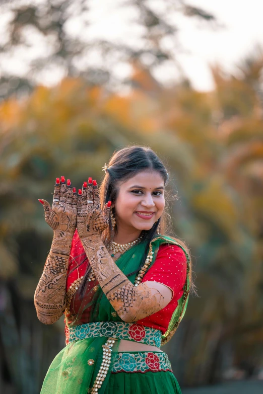 a woman dressed in a green and red outfit, pexels contest winner, hurufiyya, anjali mudra, wedding, teenage girl, fall season