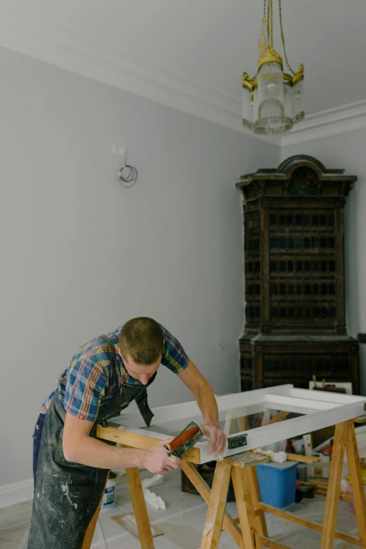 a man working on a table in a room, by Jacob de Heusch, unsplash, arbeitsrat für kunst, picture frames, low quality photo, full frame image, profile image