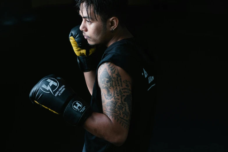 a close up of a person wearing boxing gloves, a portrait, by Robbie Trevino, pexels contest winner, black and yellow tracksuit, athletic crossfit build, avatar image, asian male