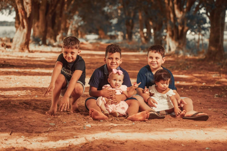 a group of children sitting on top of a dirt field, avatar image, caio santos, portrait image, babies in her lap