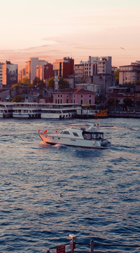 a number of boats in a body of water near a city, an album cover, by Cafer Bater, shutterstock, istanbul, high quality photo, summer evening, 3 boat in river