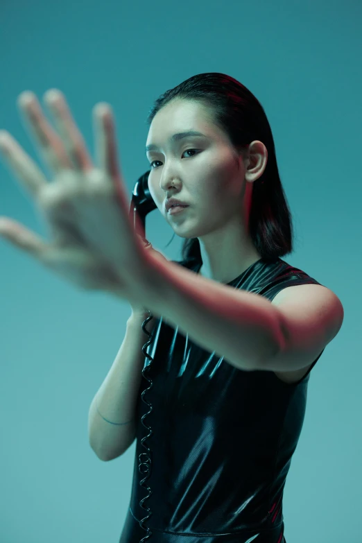 a woman in a black dress talking on a cell phone, an album cover, inspired by Feng Zhu, unsplash, neo-figurative, in a fighting pose, morphosis, nvidia promotional image, wave a hand at the camera