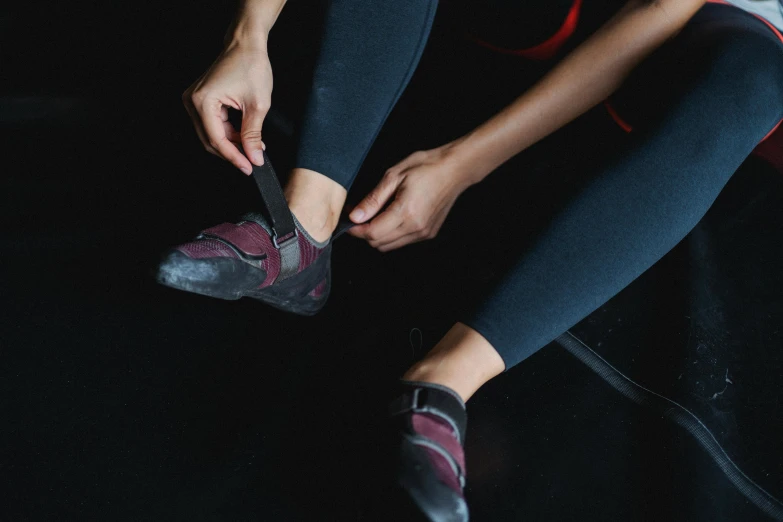 a woman tying up a pair of shoes, by Emma Andijewska, pexels contest winner, in a planet fitness, adam ondra, wine-red and grey trim, slides