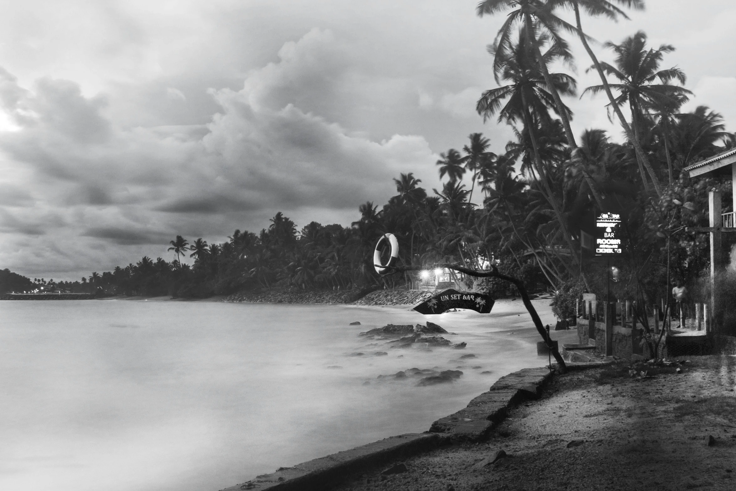 a black and white photo of a beach, by Max Dauthendey, surrealism, kerala village, saatchi art, lights, tropical atmosphere