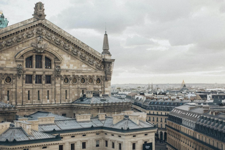 a large building with a clock on top of it, by Nina Hamnett, pexels contest winner, paris school, view from high, pointed arches, slight overcast weather, with roulettes in the roof