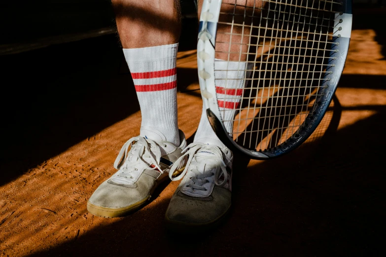 a man standing on top of a tennis court holding a racquet, pexels contest winner, striped socks, white and red color scheme, hard clay, a pair of ribbed